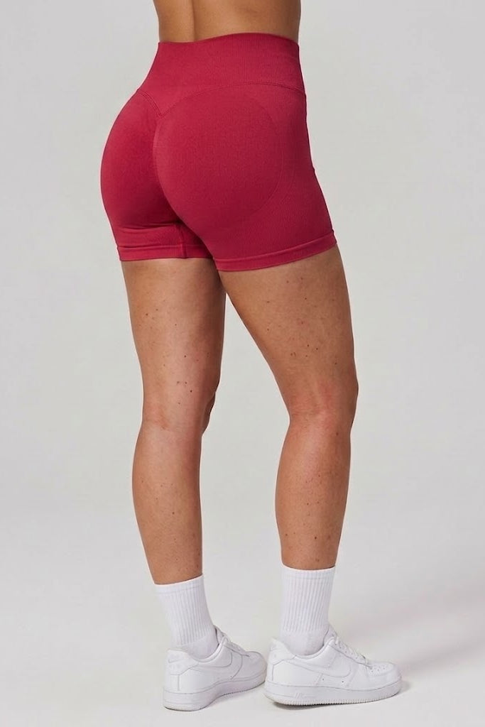 Red athletic shorts worn by a person on a plain background