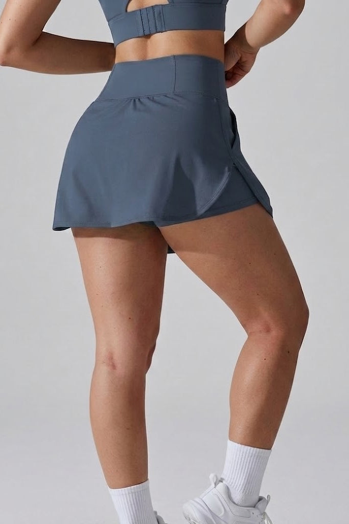 Person wearing a blue athletic skirt on a gray background