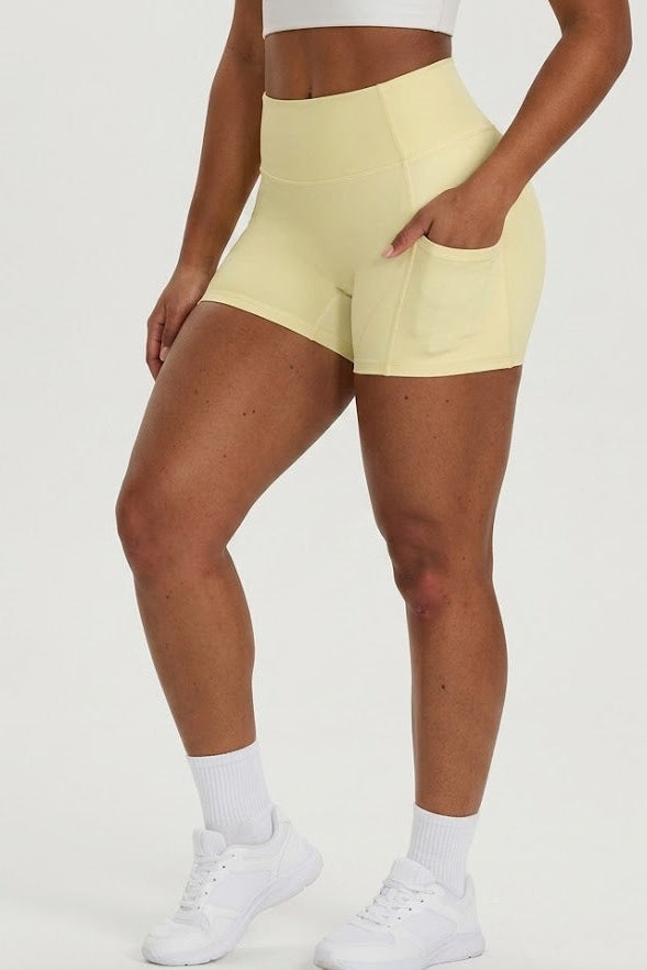 Person wearing light yellow shorts on a white background
