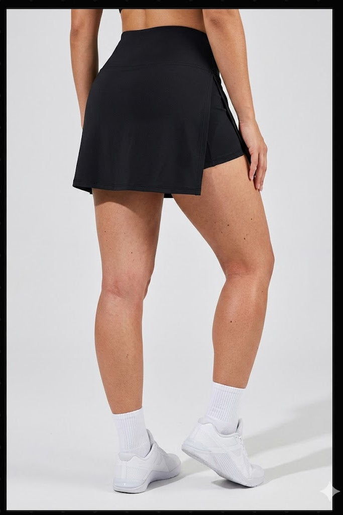 Person wearing a black skirt and white sneakers on a light gray background