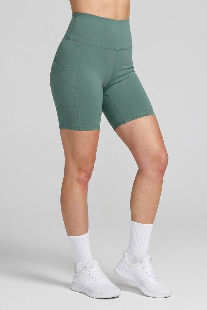 Green athletic shorts worn by a person on a gray background