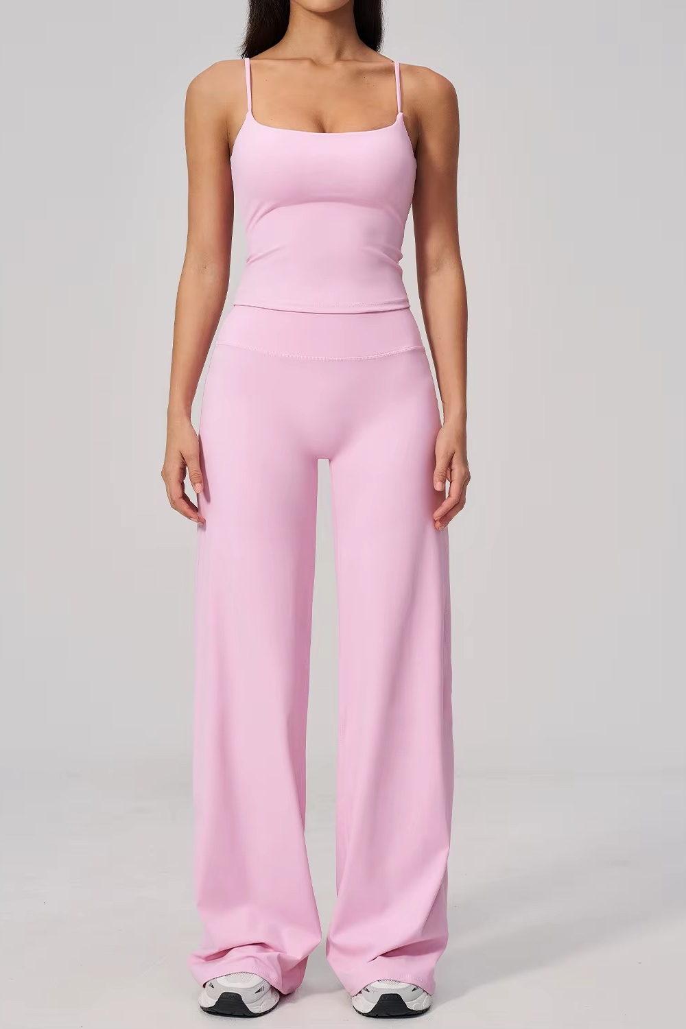 Person wearing a pink jumpsuit on a gray background