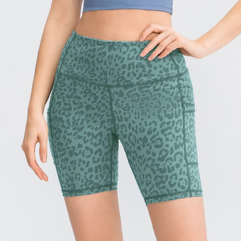 Green leopard print shorts worn by a person on a light gray background