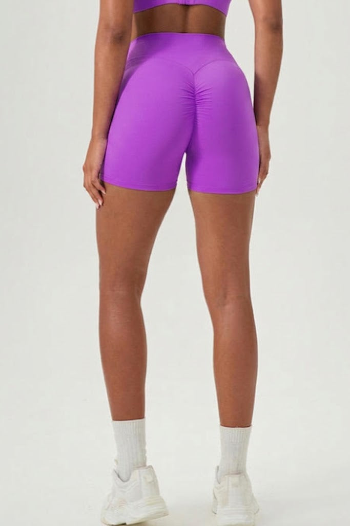 Person wearing purple athletic shorts on a white background