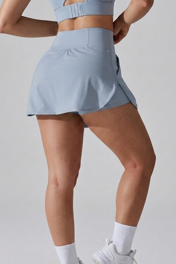 Person wearing a light blue athletic skirt on a plain background