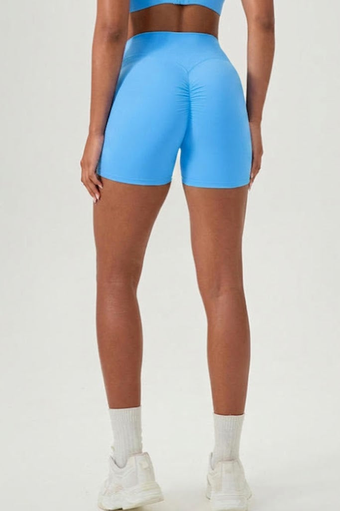 Person wearing bright blue athletic shorts on a white background