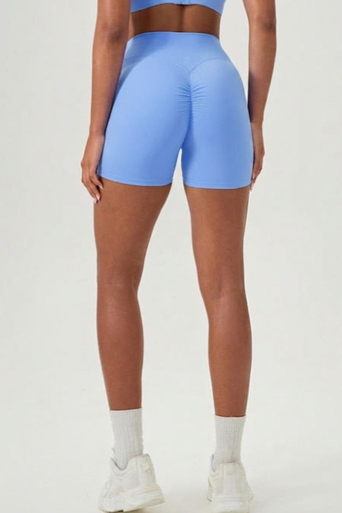 Person wearing blue athletic shorts on a white background