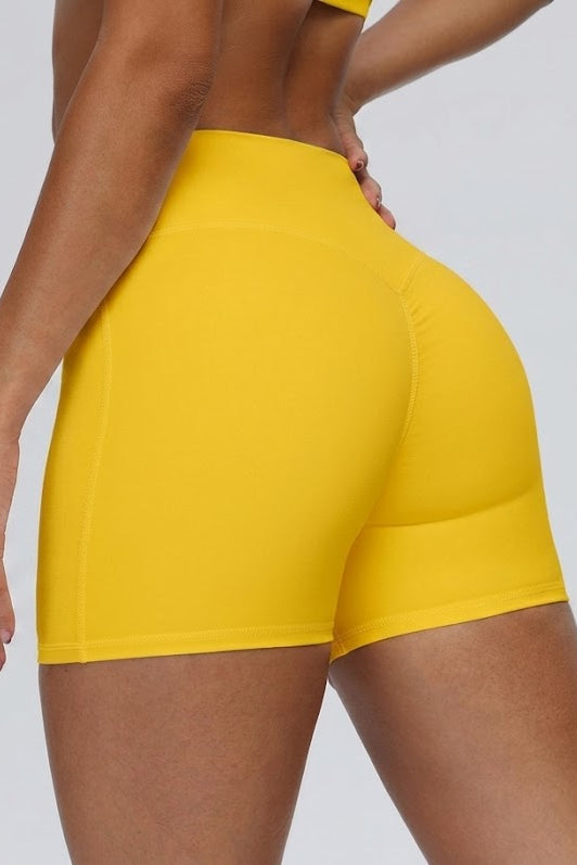 Yellow athletic shorts worn by a person on a plain background