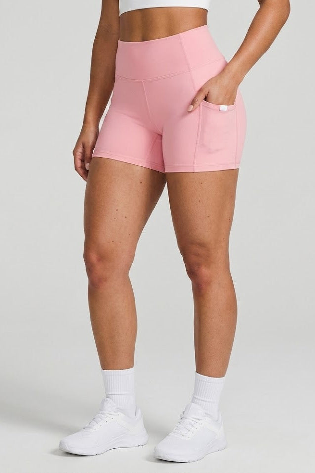 Person wearing pink shorts on a plain background